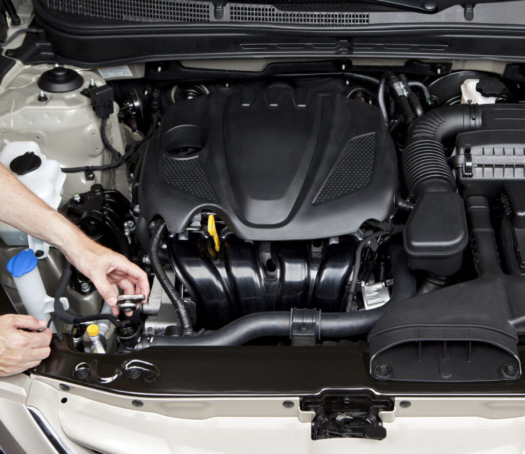 Mechanic checking antifreeze/coolant of a car engine.